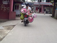 Sementara anak perempuan berbaju pink duduk membelakangi sambil memegangi sepeda yang juga berwarna pink. (Foto Suyanto).