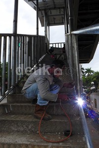 Para pekerja melakukan pembangunan tahap akhir Jembatan Penyeberangan Orang (JPO) Gambir, Jakarta, Jumat (20/12/2013).
