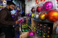 Seorang warga memilih pernak-pernik Natal.