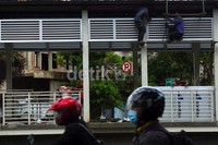Seorang pengendara melintas di depan halte busway yang tengah diperluas.