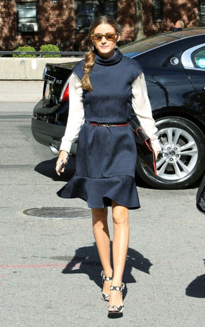 Tampilan berikutnya terinspirasi dari gaya anak sekolahan. Olivia tampil palyful dalam terusan biru navy yang memiliki lipit di bagian bawah, dan ditambahkan kemeja putih lengan panjang. Penampilannya kali ini disempurnakan dengan belt tipis merah, yang serasi dengan list di clutch yang ia bawa.