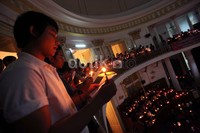 Para jemaat menyalakan lilin saat mengikuti Misa Natal di GPIB Immanuel.