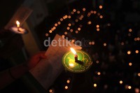 Para jemaat melantunkan lagu-lagu rohani sambil menyalakan lilin.