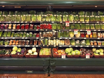Coba perhatikan gambar di atas. Di antara jejeran sayur dan buah di rak, ada seorang manusia mematung. Sudah terlihat? (kredit foto: dailymail)