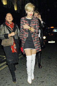 Rita Ora memberi sentuhan 60-an, memakai boot putih dari Chanel. Padanan monokrom untuk dress dan sepatunya, dibuat lebih berwarna dengan tambahan jaket printing, tas lego dan lipstik merah merona.