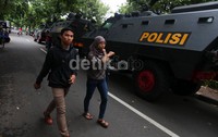 Warga melintas di samping mobil baraccuda milik Brimob.