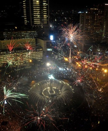 Jakarta, Indonesia ribuan orang memadati Bunderan Hotel Indonesia merayakan malam tahun baru dengan pesta kembang api yang menakjubkan. (kredit foto: Tatan Syuflana/AP Photo)