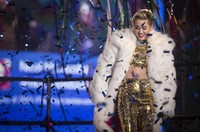 Tampil mengenakan crop top dan celana berkilau emas dipadu dengan mantel bulu berwarna putih dari The Blonds, Miley Cyrus nampak glamour. REUTERS/Carlo Allegri.
