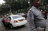Seorang pegawai Pemprov DKI Jakarta terlihat turun dari kendaraan umum.