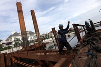 Seorang pekerja merampungkan pembangunan rumah pompa di Muara Baru, Pluit, Jakarta Utara.
