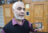     Kepala Federasi Masjid Swedia, Omar Mustafa menunjukan foto aksi vandalisme. reuters/Leif R. Jansson/TT News Agency.