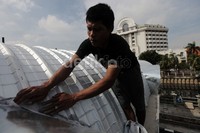 Seorang pekerja memperbaiki atap terminal.