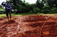 Petugas merapihkan makam Dayat Kacamata cs di TPU Pondok Rangon, Jakarta Timur.