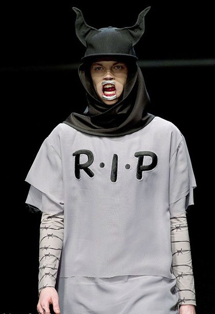 Salah satu model mengenakan T-shirt dengan cutting yang seolah tidak selesai, bertuliskan R.I.P di tengahnya. Di bagian lengan panjangnya ada motif kawat berduri.