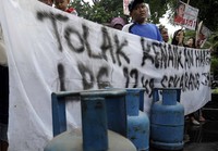 Pendemo membawa spanduk dan tabung gas elpiji.