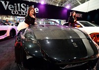Seorang model berdiri di dekat Nissan Fairlady di booth VailSide di Tokyo Auto Salon 2014. AFP/Toshifumi Kitamura.