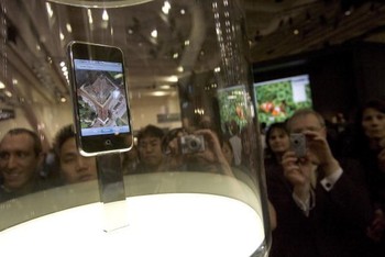 Pengunjung tampak mengerubungi iPhone generasi pertama yang ditampilkan pertama kali untuk publik.
