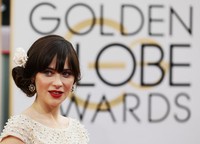 Zooey melengkapi penampilannya dengan side bun hair style yang ditata dengan hiasan bunga dari Jennifer Behr. REUTERS/Danny Moloshok.