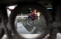 Seorang pemotor nekat menerobos banjir.