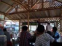 Tanpa kipas angin maupun pendingin ruangan, warung bakso sederhana ini sejuk karena angin sepoi-sepoi masuk dari dindingnya yang terbuat dari susunan batang-batang bambu.
