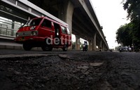 Para pengendara menghindari lubang di Jalan  Yos Sodarso, Jakarta Utara, Selasa (14/1/2014). Intensitas curah hujan yang tinggi membuat sebagian jalanan di ibukota berlubang.