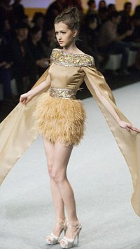 Burmas Mogok Pauk Pauk, salah seorang desainer berbakat asal Hong Kong menghadirkan koleksi bridal yang tampak modern. Misalnya saja gaun warna coklat keemasan dengan rok bulu dan taburan payet berikut ini.