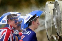 Beberapa suporter tuan rumah mendinginkan tubuhnya di kipas besar yang dipasang pihak penyelenggara di banyak tempat di sekitar arena. (Getty Images)