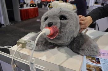 Coba lihat bentuknya? Menggemaskan bukan! Ini bukan boneka, melainkan robot yang digunakan untuk proses terapi bagi penderita Demensia, Alzheimer yang berwujud hewat anjing laut yang lucu. (kredit foto: businessinsider)