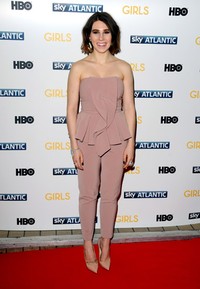Sementara Zosia Mamet memilih strapless blush jumpsuit dengan detail peplum dari Elisabetta Franchi dipadu dengan sepatu warna senada. Anthony Harvey/Getty Images.