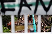 Alat berat milik Dinas Pekerjaan Umum dikerahkan untuk mengeruk jalan yang ambles.