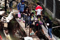     Warga terpaksa melewati pipa besi yang melintang di jalan tersebut.