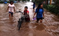 Banjir dimanfaatkan sejumlah anak untuk bermain air.