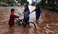 Tiga orang anak asyik bermain air.