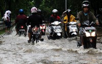 Pengendara sepeda motor menerobos banjir di Jalan Danau Sunter Utara.