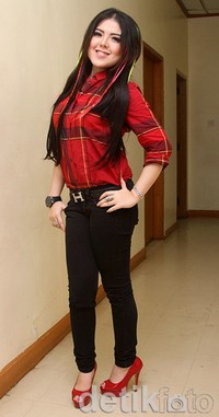 Ia memilih kemeja merah, celana hitam dan heels merah untuk penampilannya. Gus Mun/detikHOT.