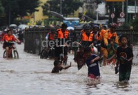 Bagi anak-anak datangnya banjir menjadi arena bermain yang menyenangkan meski terbilang cukup berbahaya