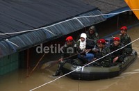 Anggota Koppasus membantu mengevakuasi beberapa warga yang masih terjebak banjir.