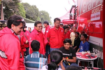     Direktur Utama Telkomsel Alex J. Sinaga (tengah) dan Direktur Sales Telkomsel Mas’ud Khamid (kanan) menyapa pelanggan yang menggunakan layanan gratis charging ponsel di  Posko Telkom Group “Peduli Korban Banjir”, Kampung Melayu, Jakarta (19/01).