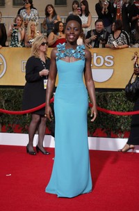Bintang '12 Years a Slave' Lupita Nyong’o memilih gaun berwarna turquoise cerah dari Gucci yang dihiasi aksen bunga di lehernya lengkap dengan perhiasan dari Fred Leighton. REUTERS/Lucy Nicholson.     