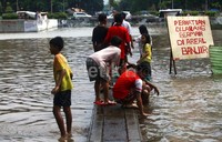 Terlihat tanda larangan bermain di areal banjir namun masih banyak anak-anak yang bermain di daerah tersebut.