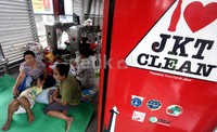 Warga menunggu banjir surut di Halte Jembatan Baru.
