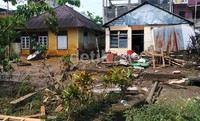 Sepanjang jalan masih terlihat bekas-bekas terpaan banjir bandang di rumah dan pertokoan milik warga.