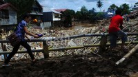 Karena masih dalam masa pembersihan, tumpukan sampah bercampur lumpur masih terlihat di pinggiran jalan.