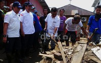 Dengan mengenakan sepatu boot dan baju PMI, JK menyambangi rumah-rumah warga korban banjir. Ia menyusuri lorong-lorong yang masih ditutupi lumpur.