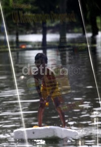     Seorang anak bermain selancar di depan kantor Satuan Penyelenggara Administrasi Surat Izin Mengemudi (Satpas SIM).