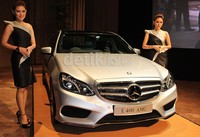 Dua orang model berpose dengan Mercedes-Benz E 400 AMG.