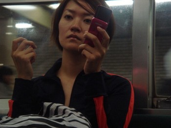 Tahun 2000an, ponsel mulai digunakan secara massal dan desainnya semakin menarik. Tampak seorang wanita muda memegangi ponselnya di kereta bawah tanah Tokyo pada tahun 2000.