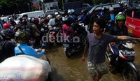 Kendaraan berusaha melintasi banjir di  perempetan Gunung Sahari depan Hotel Boutique, Kemayoran, Jakarta Pusat, Rabu (22/01/2014).