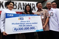 Direktur BCA Subur Tan (kanan) menyerahkan bantuan secara simbolis kepada Ketua PMI DKI Jakarta Rini Sutiyoso (kiri).