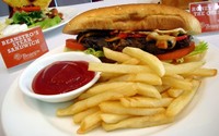 Beanstro Steak Sandwich (Rp 98.000), roti panini isi steak rib eye bakar, bawang Bombay, jamur, cabai, dan keju leleh. Disajikan bersama kentang goreng dan saus tomat.